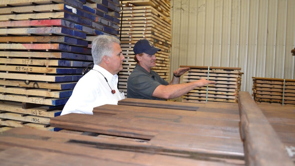 Jason Holman, left, of EcoVantage explains the lumber treatment to ISDA Director Bruce Kettler, right.