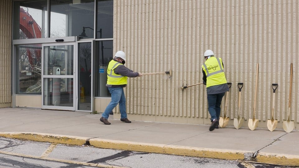 Brownsburg Town Council members Brian Jessen and Matt Simpson take part in the wall breaking ceremony of a vacant Kmart. (photo courtesy: Kroger).