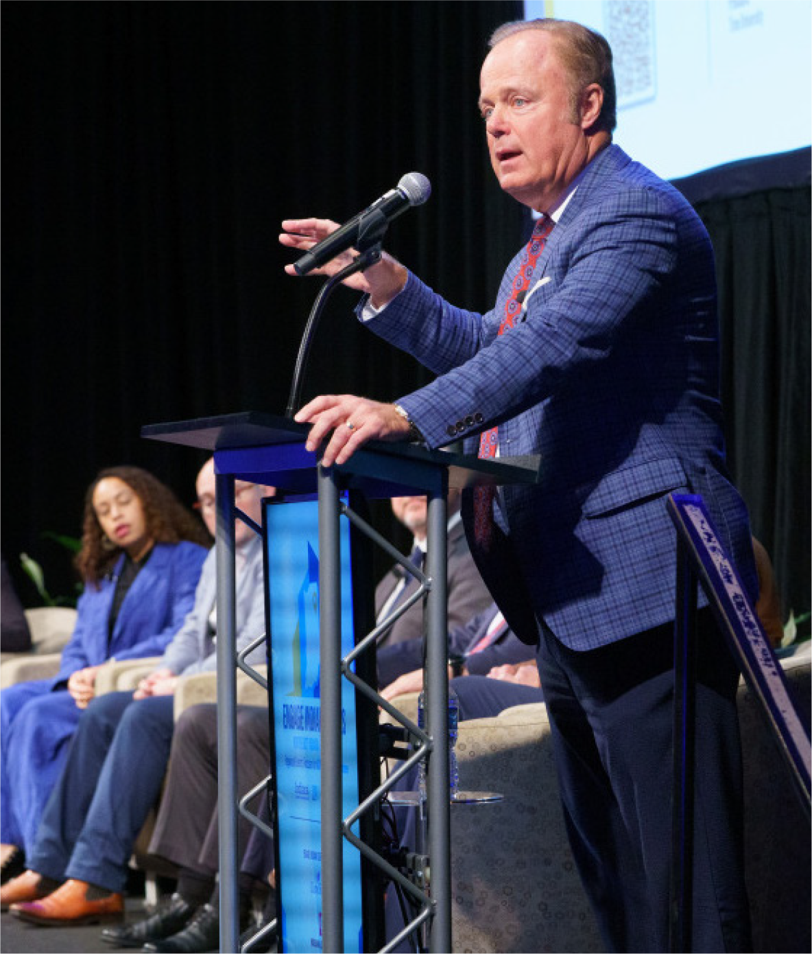 Inside INdiana Business division president Gerry Dick speaking into a microphone at a podium.